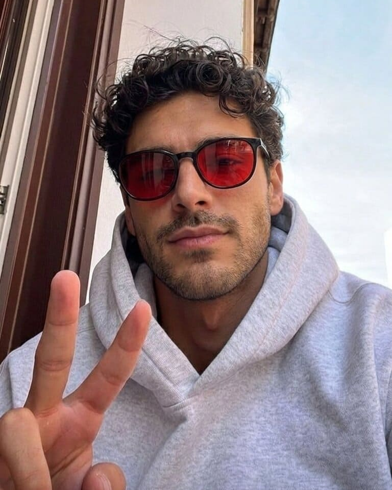 Red-lens glasses with a gray hoodie by a window